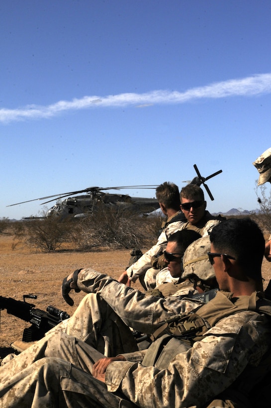 Marines with E Company, 2nd Battalion, 7th Marine Regiment, use down time to discuss what they’re going to do after completing Operation War Wagon while a CH-53E Super Stallion is prepped for take off during the final exercise of the recent Weapons and Tactics Instructor course at Auxiliary Airfield 6 on the Barry M. Goldwater Range in Ariz., Oct. 30, 2010. The training exercise tested the skills learned by the WTI students and included the participation of approximately 250 infantry Marines from the battalion.