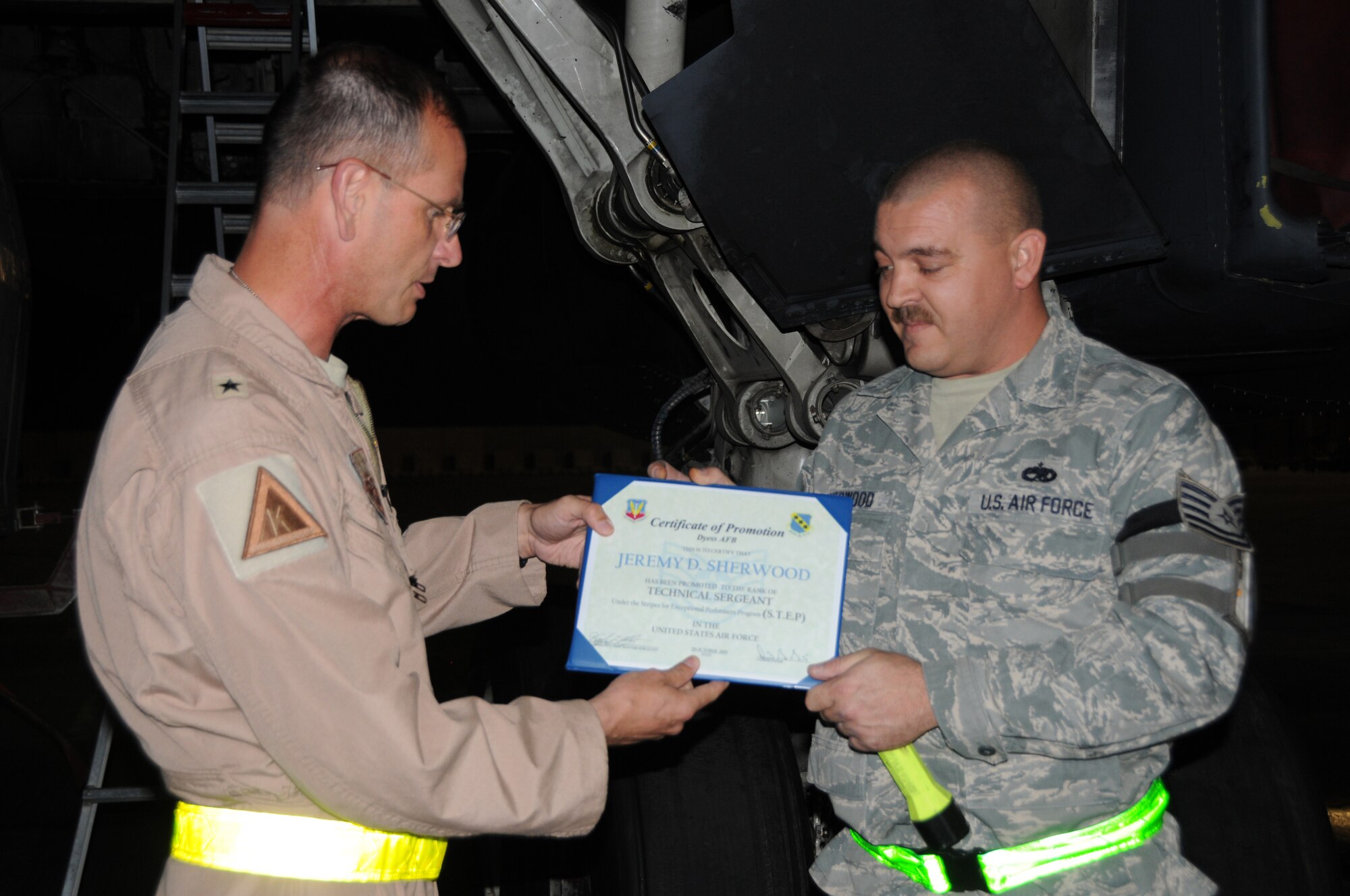 SOUTHWEST ASIA - Brig. Gen. Randy Kee, 379th Air Expeditionary Wing Commander, awards Staff Sgt. Jeremy Sherwood, Aircraft Fuel Systems Craftsman, a STEP promotion to Tech. Sgt. here Oct. 29. The Stripes for Exceptional Performers program recognizes outstanding individuals by promoting them instantly. Sergeant Sherwood's home unit is the 7th Component Maintenance Squadron from Dyess Air Force Base, Texas and is currently deployed with the 379th Expeditionary Maintenance Squadron. (U.S. Air Force photo/Tech. Sgt. Kimberly Spinner)