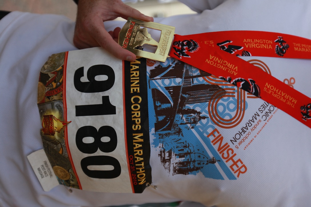 Petty Officer Third Class Travis Haley, a hospital corpsman with Chemical Biological Incident Response Force, Marine Forces North, displays the award he received after finishing the annual Marine Corps Marathon. The marathon is one of several Haley will be running to raise money for the Wounded Warriors Project.