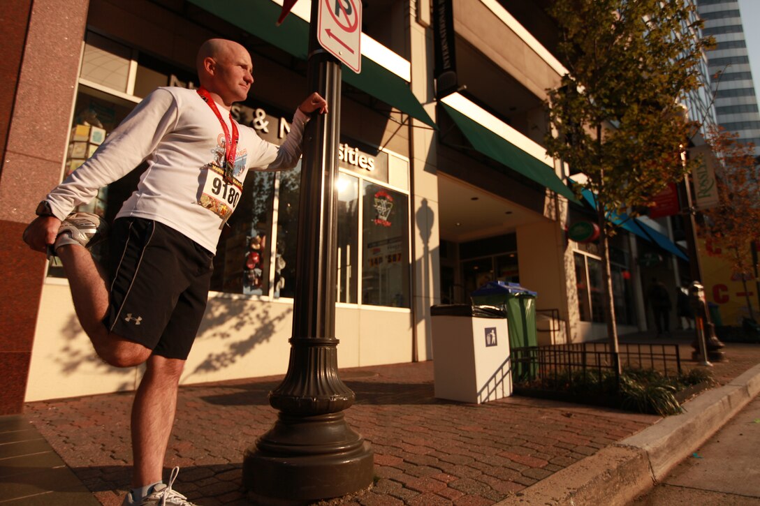 Petty Officer Third Class Travis Haley, a hospital corpsman with Chemical Biological Incident Response Force, Marine Forces North, stretches out after completing the annual Marine Corps Marathon. The marathon is one of several Haley will be running to raise money for the Wounded Warriors Project.