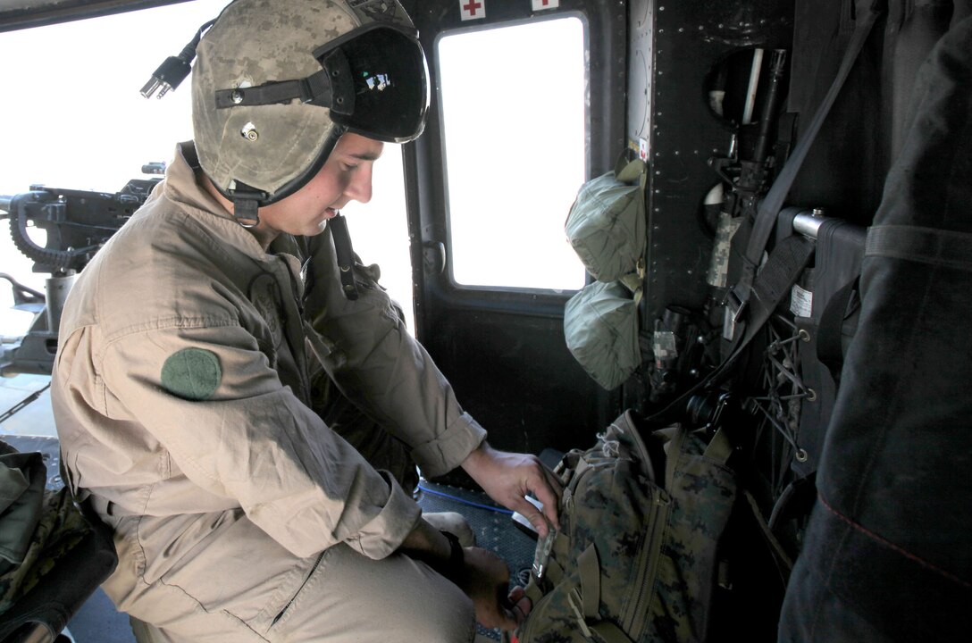 Sgt. Carson Ferraro, a UH-1Y Huey crew chief with Marine Light Attack Helicopter Squadron 369, 3rd Marine Aircraft Wing (Forward), prepares his gear on the troops in contact, or TIC, response Huey. Marines ensure the aircraft is prepared for a quick start-up and takeoff in case the squadron is called on to support ground troops. One Huey and one AH-1W Cobra are always on call to fill the position of TIC response aircraft.