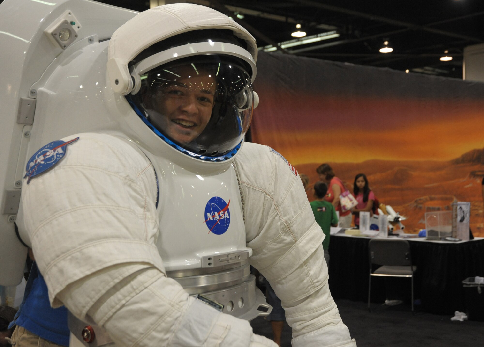 A future astronaut tries on a spacesuit in Education Alley at the AIAA Space 2010 conference, Sept.1.  (Photo by Joe Juarez)