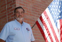 LAUGHLIN AIR FORCE BASE, Texas – Steve Rosalez, 47th Maintenance Directorate, stands next to a U.S Flag at Laughlin. Rosalez is calling for worn, torn and faded flags to be retired at 6 p.m., Sept. 11 at the Val Verde County Fairgrounds Grandstand. Rosalez supports PROJECT: Pledge of Allegiance by providing nearly 400 flags a year to be respectfully retired. (U.S. Air Force Photo/ 2nd Lt. Miles Morse)