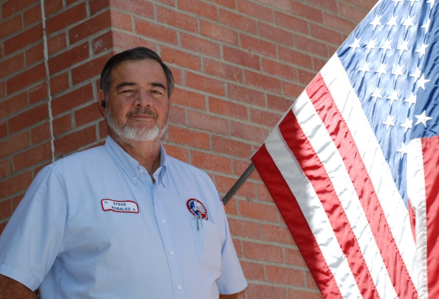 LAUGHLIN AIR FORCE BASE, Texas – Steve Rosalez, 47th Maintenance Directorate, stands next to a U.S Flag at Laughlin. Rosalez is calling for worn, torn and faded flags to be retired at 6 p.m., Sept. 11 at the Val Verde County Fairgrounds Grandstand. Rosalez supports PROJECT: Pledge of Allegiance by providing nearly 400 flags a year to be respectfully retired. (U.S. Air Force Photo/ 2nd Lt. Miles Morse)