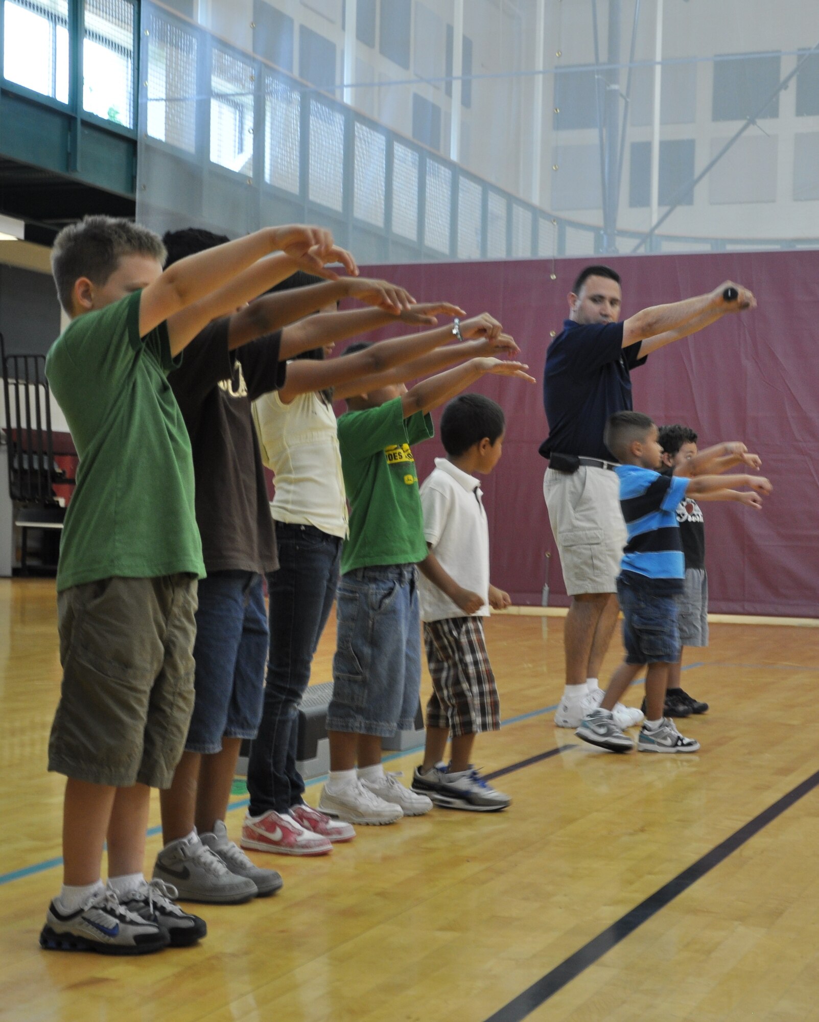 LAUGHLIN AIR FORCE BASE, Texas – Ray Torres, Laughlin’s Health and Wellness Center exercise physiologist and fitness program manager, demonstrates to children from the youth center how to properly lift weights during an exercise class the Losano Fitness Center here in July. The HAWC will be offering weekly, evening fitness and health classes for children. (U.S. Air Force Photo by 2nd Lt. Kenneth Gilbert)