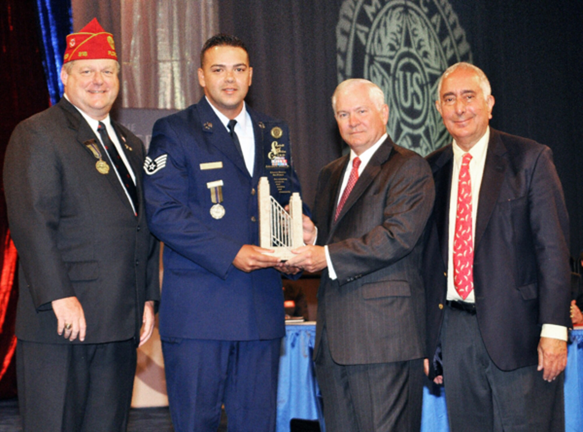Staff Sgt. Edward L. Perez, Air Force recipient of the American Legion’s 2010 Spirit of Service Award, shares the moment with (from left) American Legion National Commander Clarence E. Hill, Secretary of Defense Robert Gates and actor-entertainer Ben Stein.  Sergeant Perez, along with a member of each of the other services, received the award Aug. 31, 2010, at the organization's 92nd National Convention in Milwaukee, Wis.  (Courtesy photo/Tom Strattman)