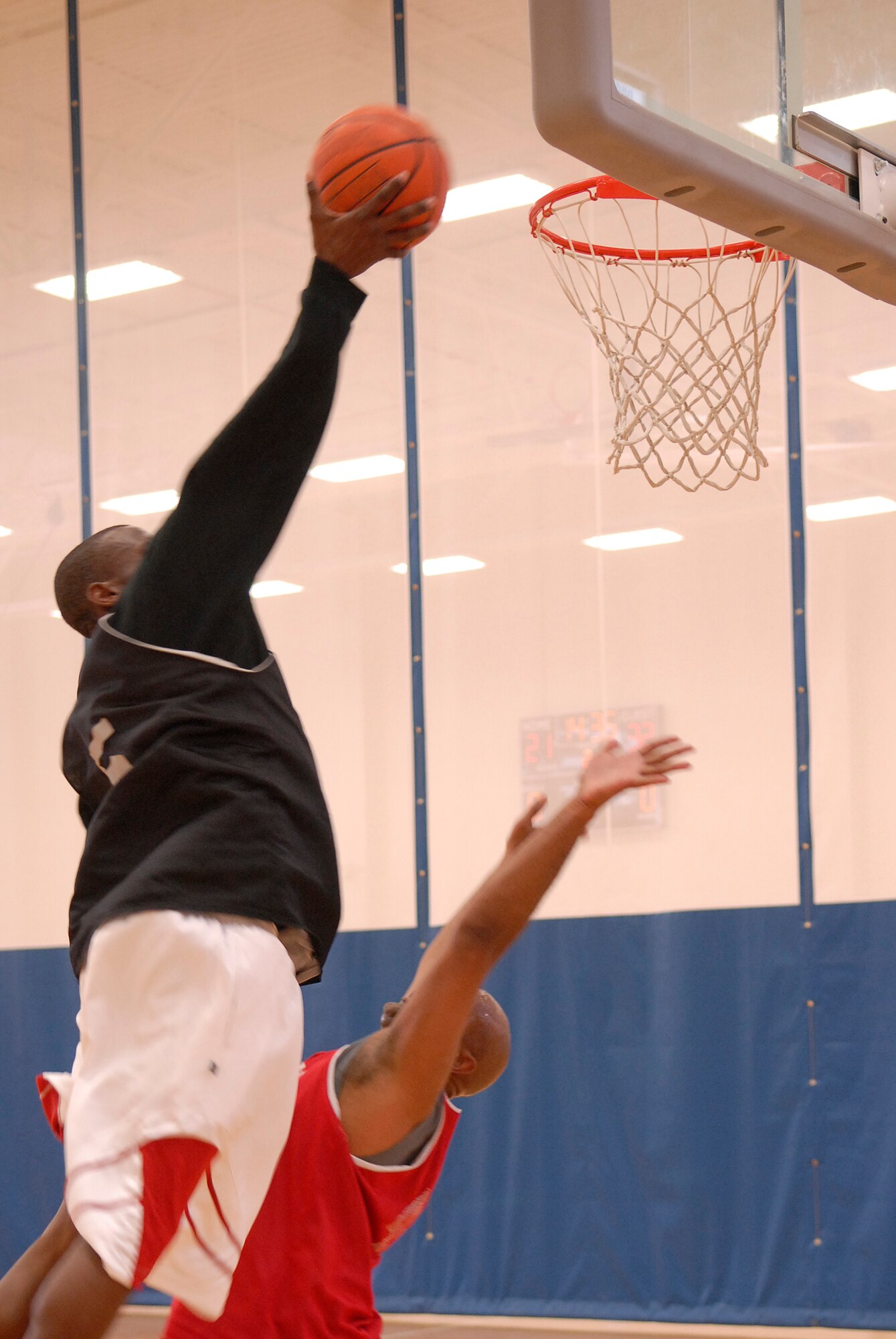 VANDENBERG AIR FORCE BASE, Calif. -- Leaping over his opponent, Anthoney Kilgore, a 30th Launch Group team member, reaches for the basket during the over 30 intramural basketball league finals at the base fitness center here Monday, Aug. 30, 2010.  The 30th LCG team won 49-39.  (U.S. Air Force photo/Senior Airman Andrew Satran) 

 
 
 

 

 
 
 

 