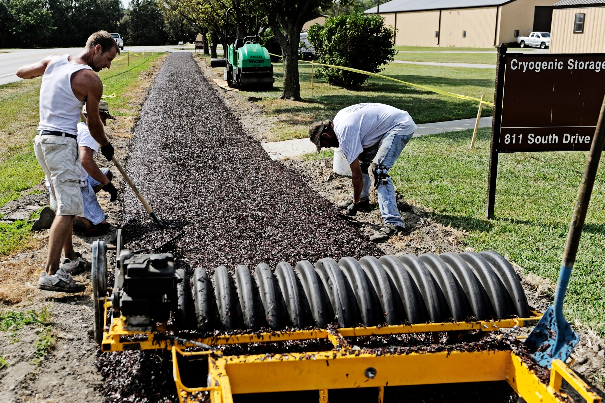 SCOTT AIR FORCE BASE, Ill. -- Contractors from Play Place install a new rubberized track alongside South Drive in addition to the two mile stretch by the fitness center August 31. (U.S. Air Force photo/ Staff Sgt. Ryan Crane)