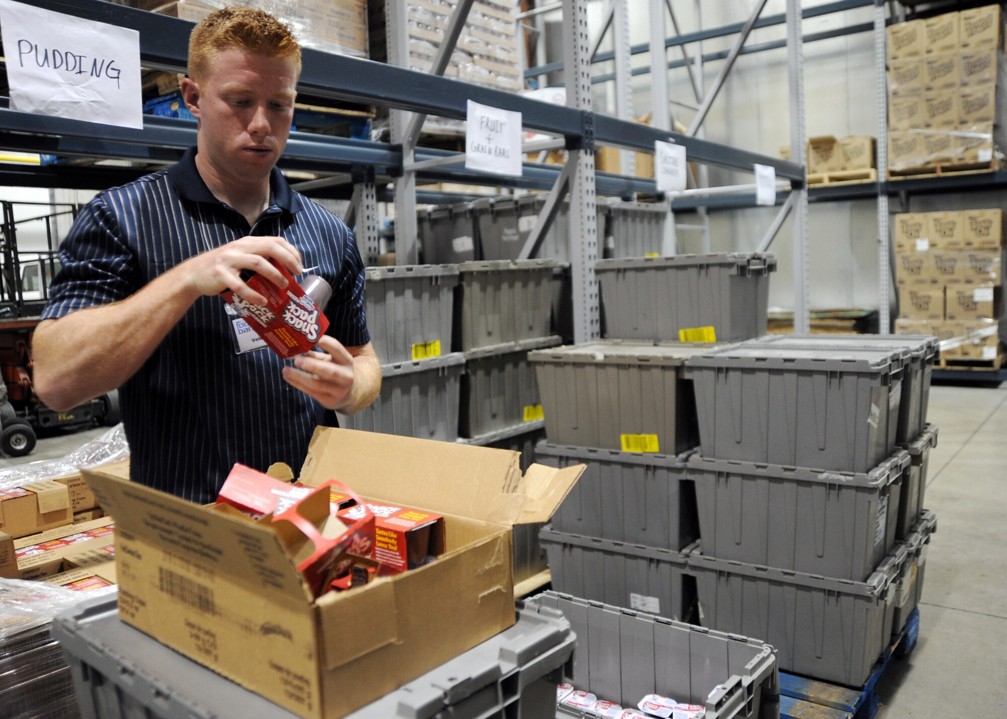 Airman 1st Class Stuart Guthrie, 22nd Aircraft Maintenance Squadron crew chief and Air Force Sergeant’s Association Chapter 972 member, places pudding cups in a container at the Kansas Food Bank for the “Backpack for Kids” program Aug. 27, 2010, Wichita, Kan.  AFSA members volunteered three hours making food packs for Wichita families and were given an opportunity to get a “hands-on” approach to help fight hunger.  (U.S. Air Force photo/Airman 1st Class Andrea Salazar)