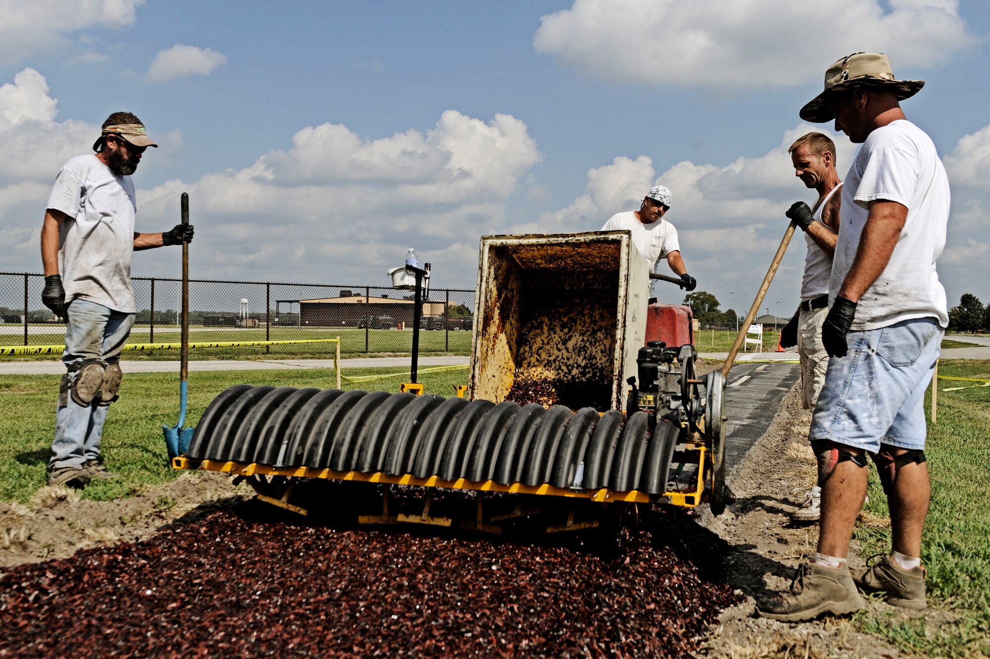 SCOTT AIR FORCE BASE, Ill. -- Contractors from Play Place install a new rubberized track alongside South Drive in addition to the two mile stretch by the fitness center August 31. (U.S. Air Force photo/ Staff Sgt. Ryan Crane)