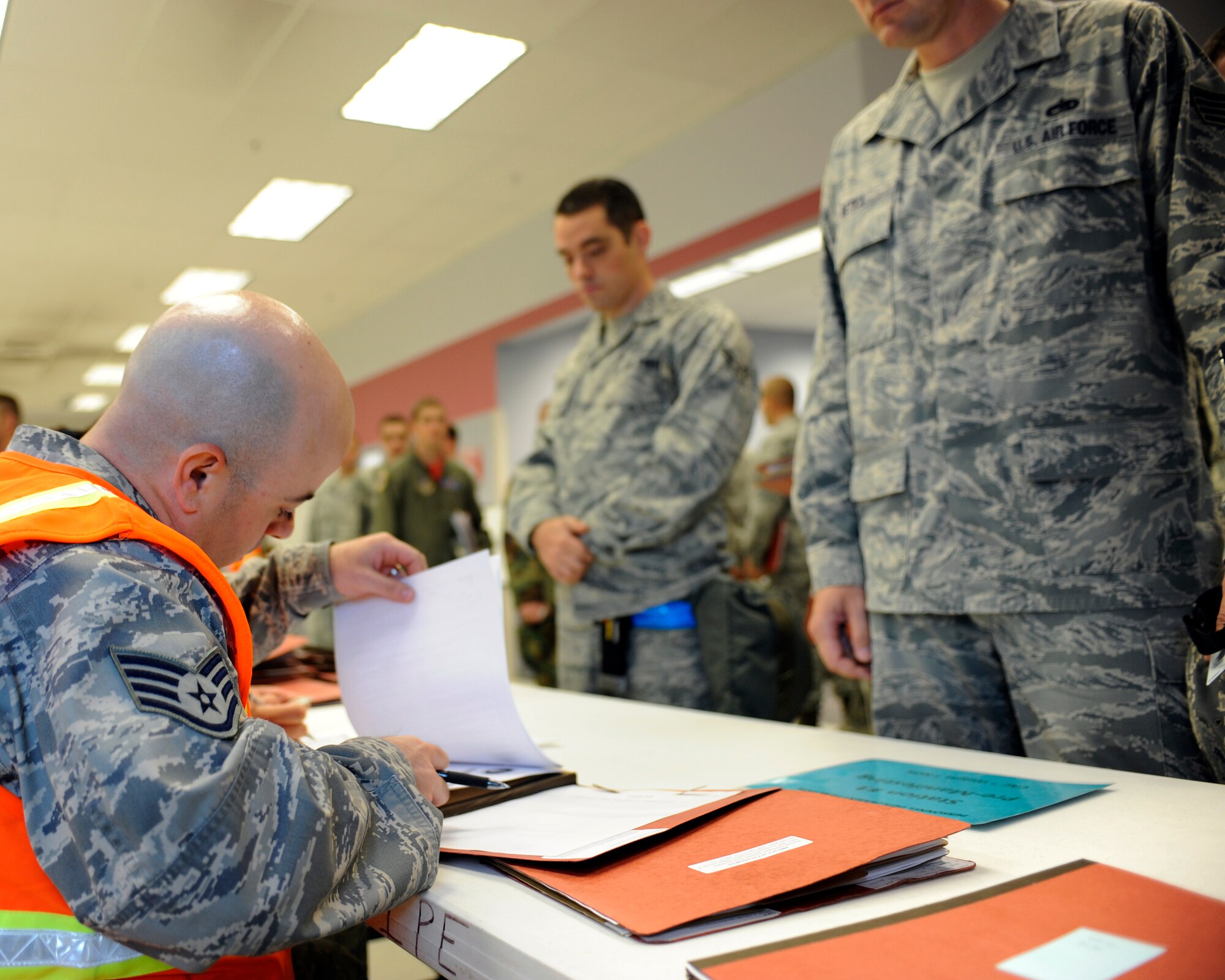 Airmen from the 354th Fighter Wing wait in line to have their deployment folders checked August 27, 2010, Eielson Air Force Base, Alaska. Deploying Airmen are required to come to the Joint Mobility Center to finalize out processing.  The Airmen are deploying in support of Valiant Shield in the south-east Asia region. (U.S. Air Force photo/Senior Airman Willard E. Grande II)