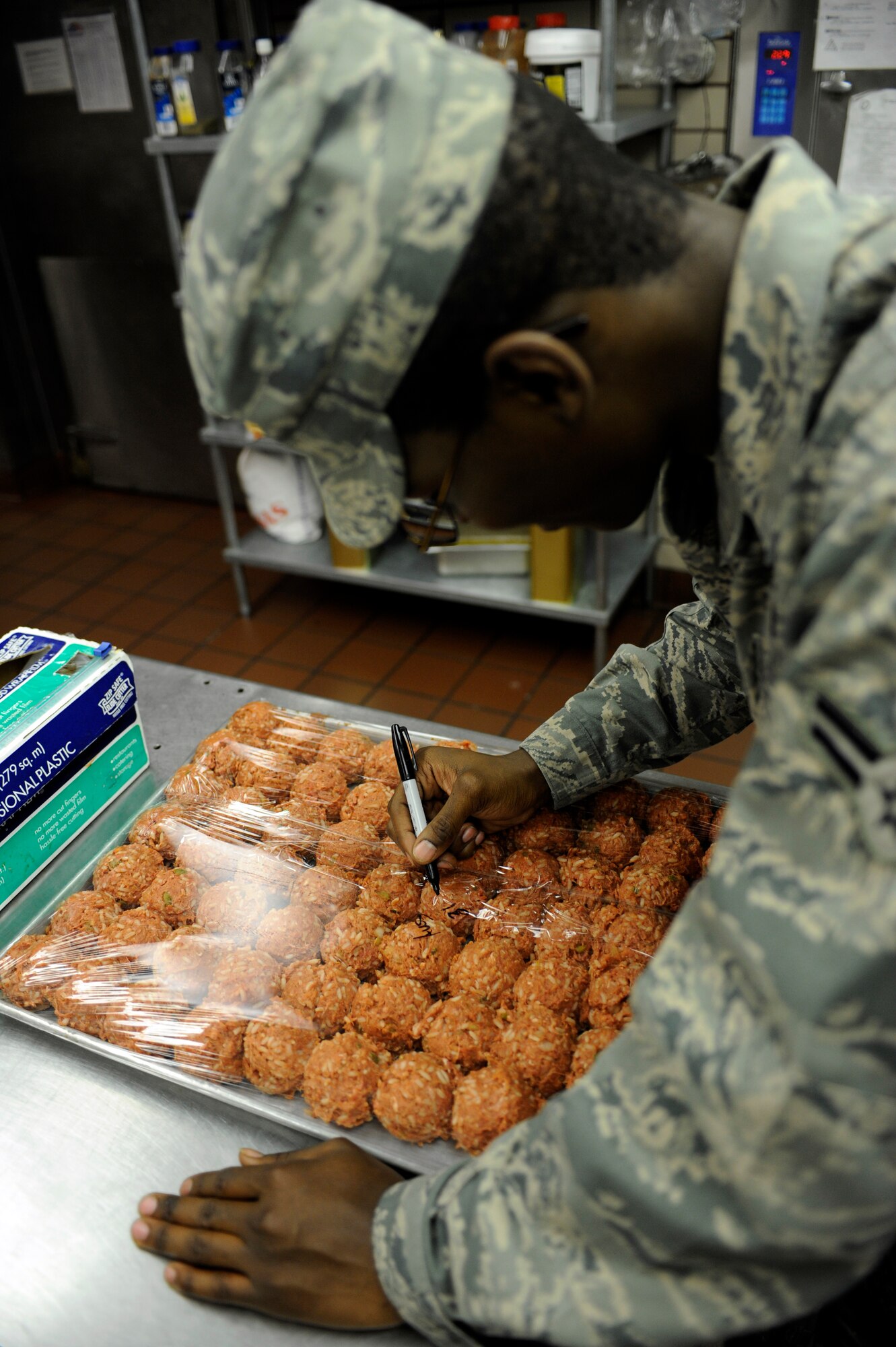 Senior Airman Paul Davis molds meat and rice into balls August 31, 2010, Eielson Air Force Base, Alaska. Airman Davis is preparing the days dinner which will feed hungry Airmen on Eielson. Airman Davis is assigned to the 354th Force Support Squadron. (U.S. Air Force photo/Senior Airman Willard E. Grande II)