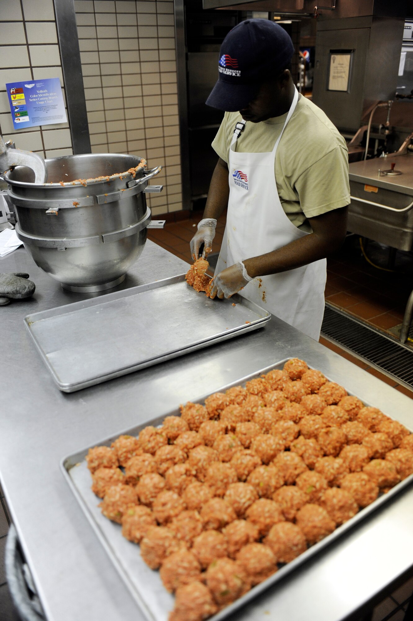 Senior Airman Paul Davis places balls of meat and rice on to baking sheets August 31, 2010, Eielson Air Force Base, Alaska. Airman Davis will refrigerate the meat balls until they are ready to be cooked for dinner. Airman Davis is assigned to the 354th Force Support Squadron. (U.S. Air Force photo/Senior Airman Willard E. Grande II)