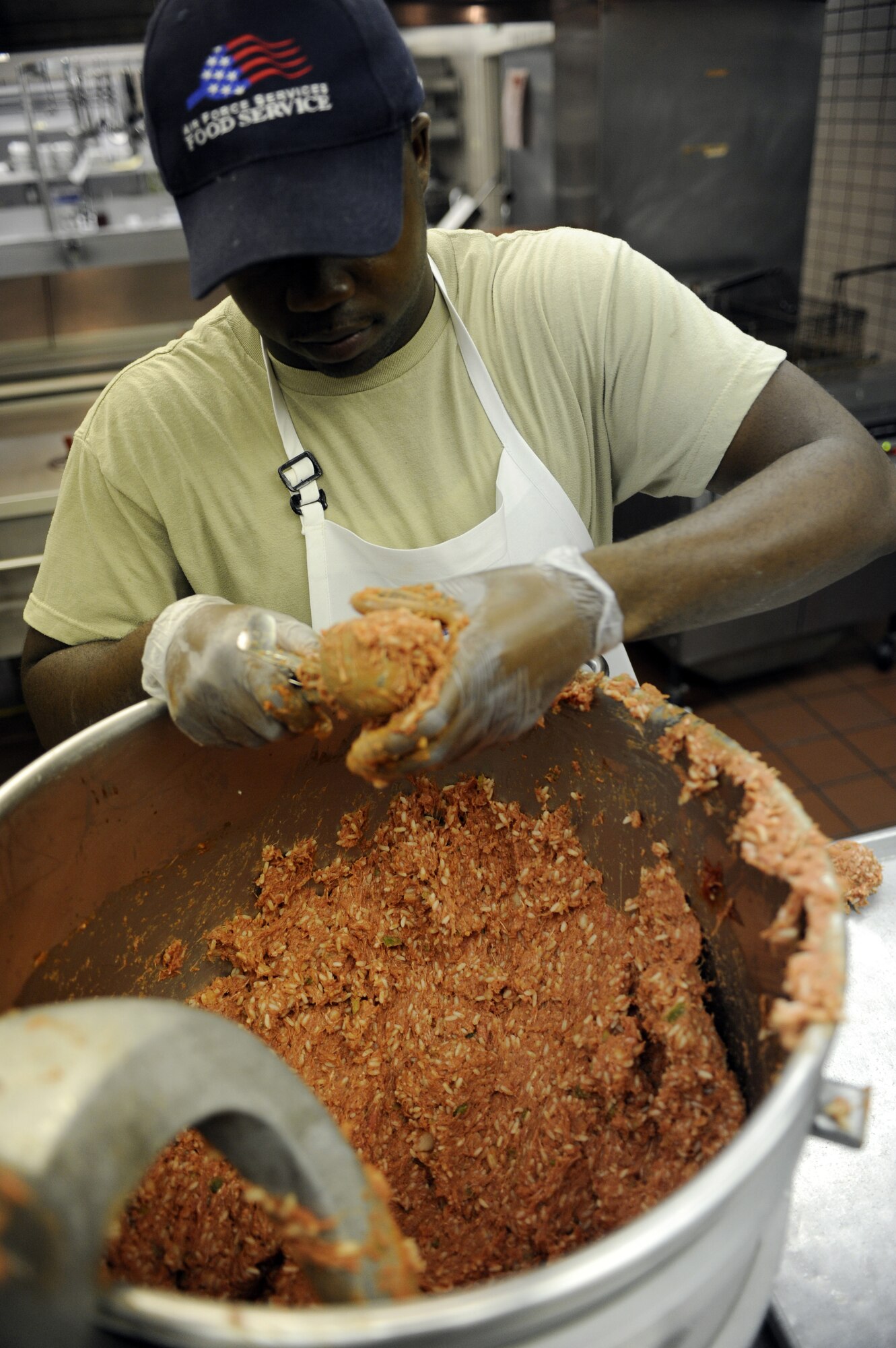 Senior Airman Paul Davis mixes meat and rice August 31, 2010, Eielson Air Force Base, Alaska. Airman Davis will mold the meat into balls then refrigerate the meat until they are ready to be cooked for dinner. Airman Davis is assigned to the 354th Force Support Squadron. (U.S. Air Force photo/Senior Airman Willard E. Grande II)