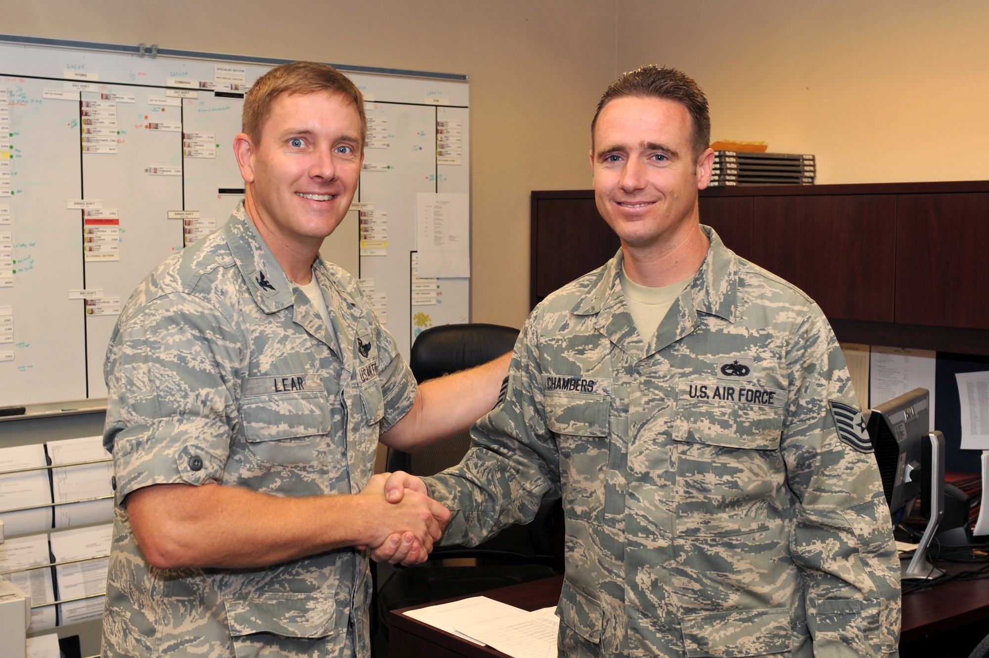 Col. Kirk Lear (left), 314th Airlift Wing vice commander, presents a coin Sept.1 here to Tech. Sgt. Christopher Chambers, 314th Aircraft Maintenance Squadron specialist section chief, for his selection as the Combat Airlifter of the Week. Sergeant Chambers led a team of Airmen who performed acceptance inspections on two C-130E aircraft for the Polish air force, strengthening U.S. and Polish relations. (U.S. Air Force photo by Staff Sgt. Chris Willis)