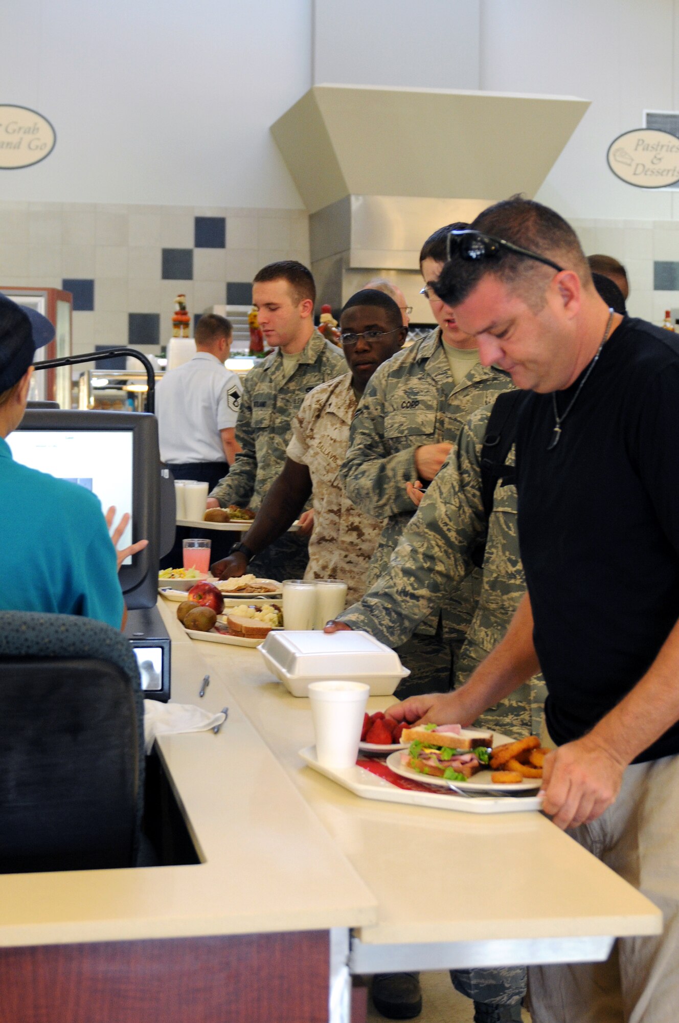 Customers pay for their meals Aug. 23 at the Hercules Dining Facilty. Active-duty members are the largest customer demographic served at the dining facility, but contractors, retirees and families are also welcome. (Courtesy photo by Ashley Mangin)