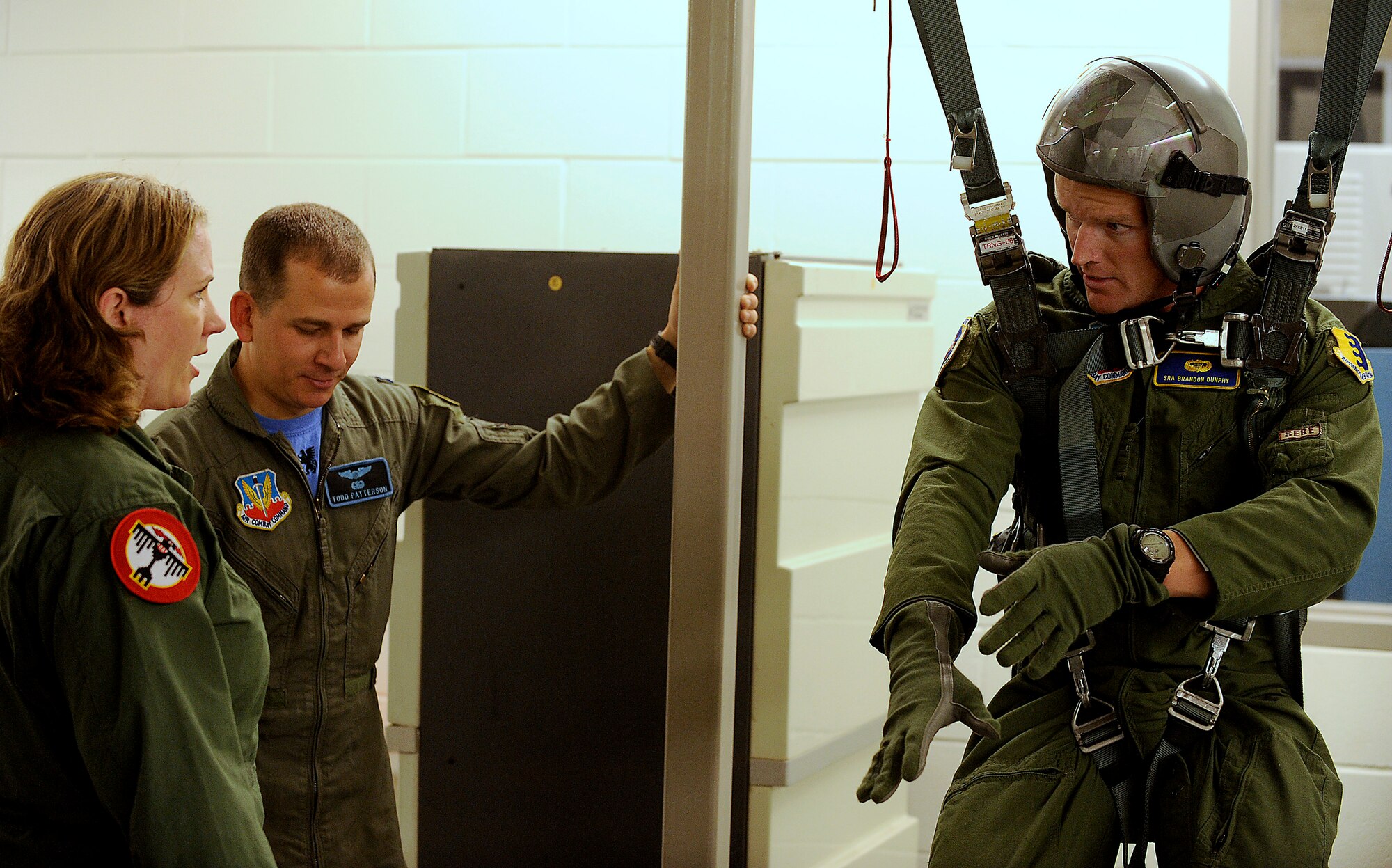 Senior Airman Brandon Dunphy, a survival, evasion, resistance and escape specialist, suspended on right, and Capt. Todd Patterson, a wing aircrew flight equipment officer, brief Under Secretary of the Air Force Erin Conaton before a flight she took on a B-1 Lancer from the 34th Bomb Squadron, Aug. 27, 2010, at Ellsworth Air Force Base, S.D.  Ms. Conaton made a visit to Ellsworth last week for a mission orientation.  (U.S. Air Force photo/Scott M. Ash)
