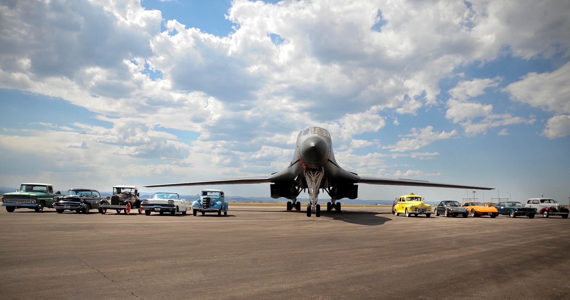ELLSWORTH AIR FORCE BASE, S.D. – Vehicles from the Rollin’ Oldies Car Club park next to a B-1B Lancer during a base tour, Aug. 27. Rollin’ Oldies Car Club members experienced a firsthand look of Ellsworth Air Force Base and various squadron demonstrations during their tour. (U.S. Air Force photo/Senior Airman Corey Hook)