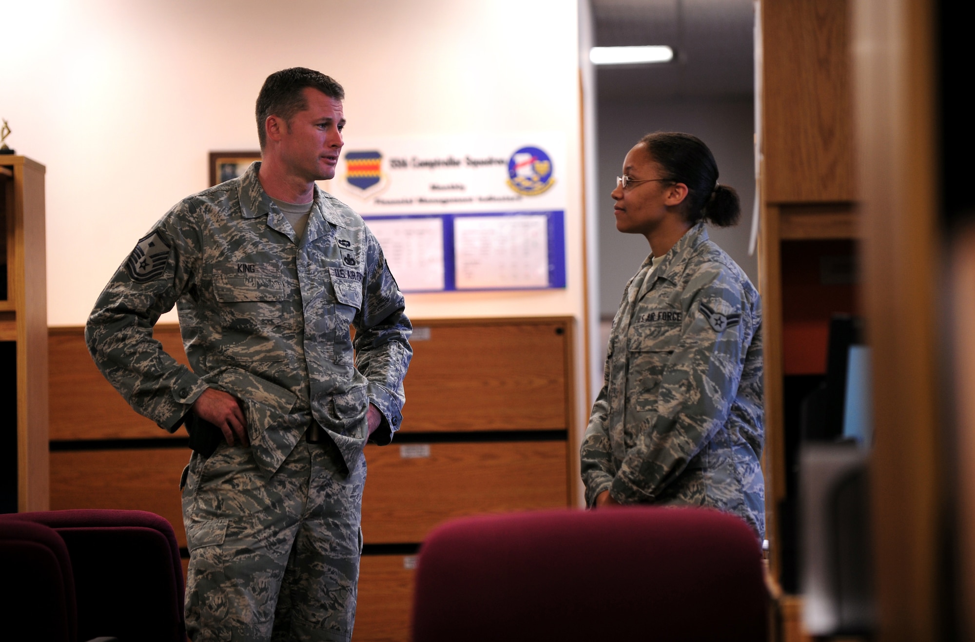 OFFUTT AIR FORCE BASE, Neb. - Master Sgt. Justin King, first sergeant for the 55th Wing staff, meets with Airman 1st Class Desirae White, a customer service technician with the 55th Comptroller Squadron, as part of his daily rounds, Aug. 25. Sergeant King handles many administrative duties and administers corrective actions when necessary to members under the commander's authority. U.S. Air Force photo by Josh Plueger
