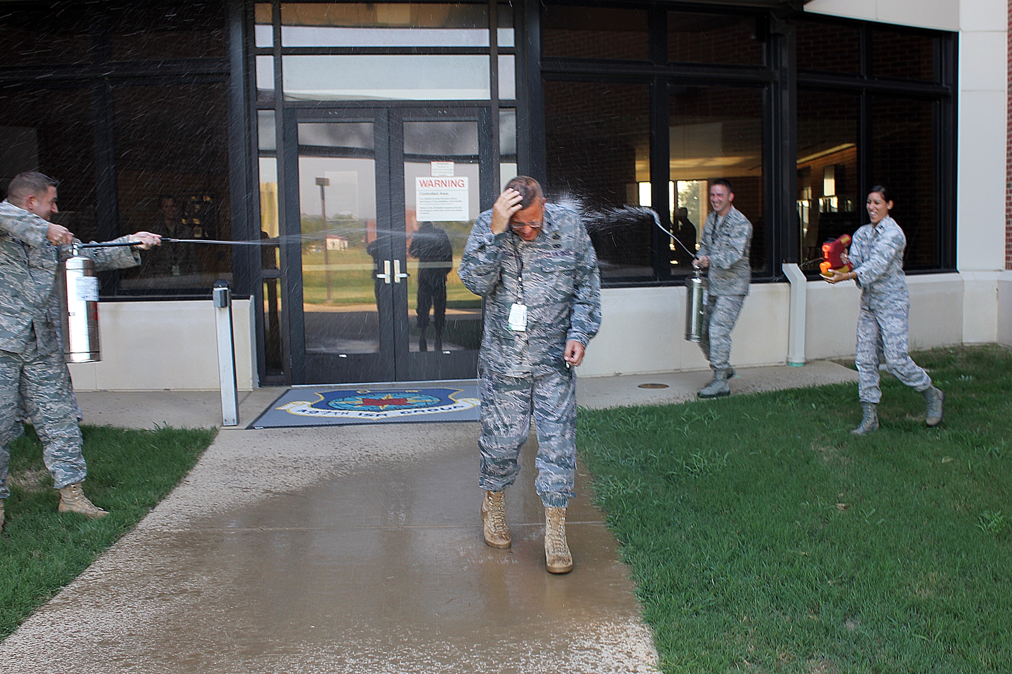 Col. Daniel R. Johnson, commander of the 480th Intelligence, Surveillance and Reconnaissance Wing, sat his final mission as an ISR mission commander in the Air Force Distributed Common Ground System Aug. 31 at Langley Air Force Base, Va.  Holding true to Air Force tradition, Colonel Johnson was hosed down in honor of his final mission, where he vectored ISR asset coverage in Afghanistan. Colonel Johnson is set to retire Sept. 9. (U.S. Air Force photo by Capt. Christopher Lohan)