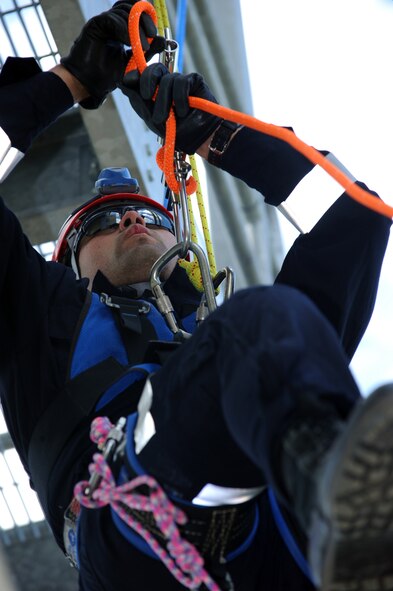 MINOT AIR FORCE BASE, N.D. -- Airman 1st Class Isaac Lazo, 5th Civil Engineer Squadron firefighter, descends the fire department training facility during an exercise here Aug. 24. Civilian firefighters from River Oakes, Ohio train base firefighters how to repel for “high and go” rope rescue scenarios, ascending, line changes and passing knots. (U.S. Air Force photo by Airman 1st Class Aaron-Forrest Wainwright)