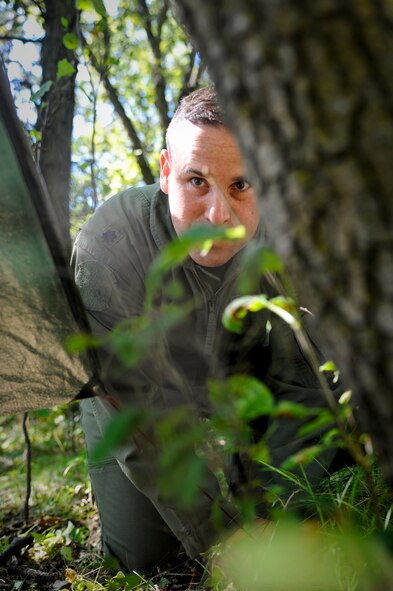 SOMEWHERE IN THE TURTLE MOUNTAINS, N.D. -- Lt. Col. Jay Tewksbury, 54th Helicopter Squadron commander, constructs a shelter during a two-day survival, evasion, resistance and escape refresher course here Aug. 25. Aircrew members of the 54th HS participated in a SERE refresher course which focused only on the evasion and survival portions of the training. (U.S. Air Force photo by Senior Airman Benjamin Stratton)