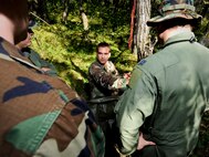 SOMEWHERE IN THE TURTLE MOUNTAINS, N.D. -- Staff Sgt. Brett Sipe, 5th Operations Support Squadron base survival, evasion, resistance and escape instructor, shows aircrew members of the 54th Helicopter Squadron how to properly setup shelter if in a survival and evasion situation here Aug. 25. Aircrew members of the 54th HS endured a two-day SERE refresher course. This course focused only on the evasion and survival portions of the course. (U.S. Air Force photo by Senior Airman Benjamin Stratton)