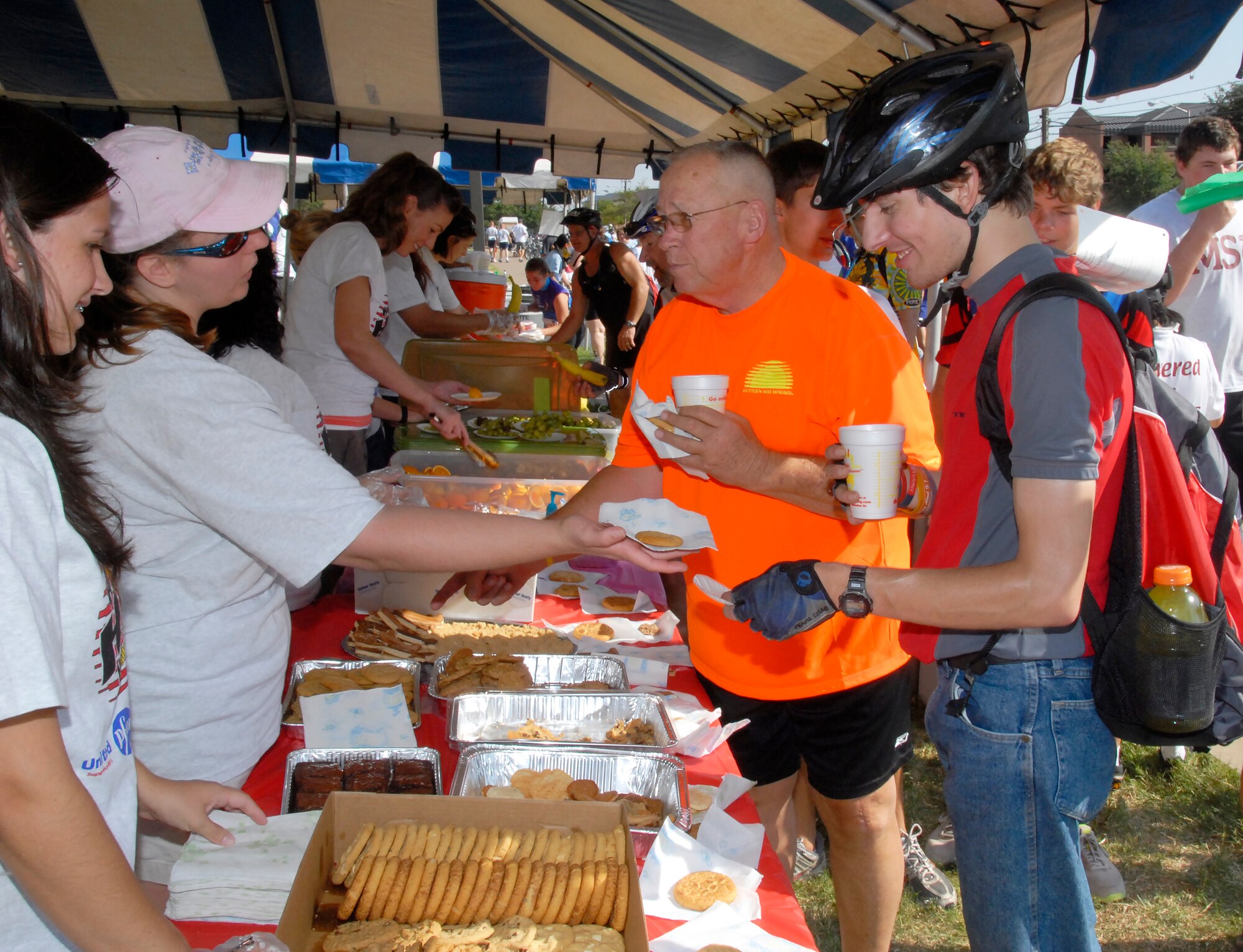 The “Pits” Stop workers hand out water and snacks to Hotter ‘n Hell Hundred cyclists who are stopping for a break and some refreshments Aug. 28 at Sheppard Air Force Base, Texas.  The “Pits” Stop supplied riders with water, snacks, a display of Sheppard heritage and technology, and encouragement as Sheppard Airmen cheered for them on their way to the rest stop.  (U.S. Air Force photo/Mike Litteken)