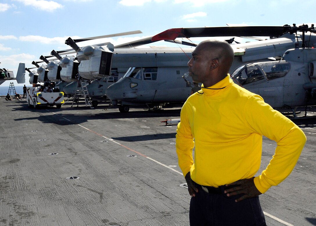 U.S. Navy Petty Officer 2nd Class Alphonso Gray monitors the repositioning of aircraft for flight operations on the flight deck of amphibious assault ship USS Kearsarge at sea, Aug. 31, 2010. 