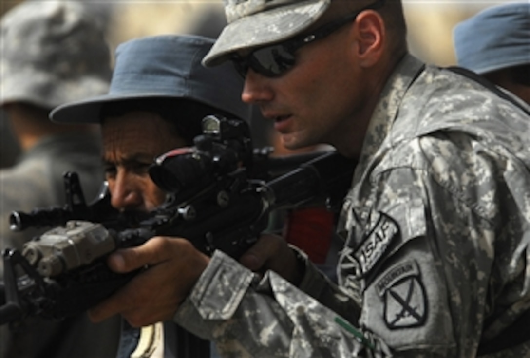 U.S. Army Sgt. James Henderson (right) of the 1st Battalion, 87th Infantry Regiment, 10th Mountain Division assists an Afghan National Police officer during call-out training at the police headquarters in Chahar Dara, Afghanistan, on Aug. 28, 2010.  