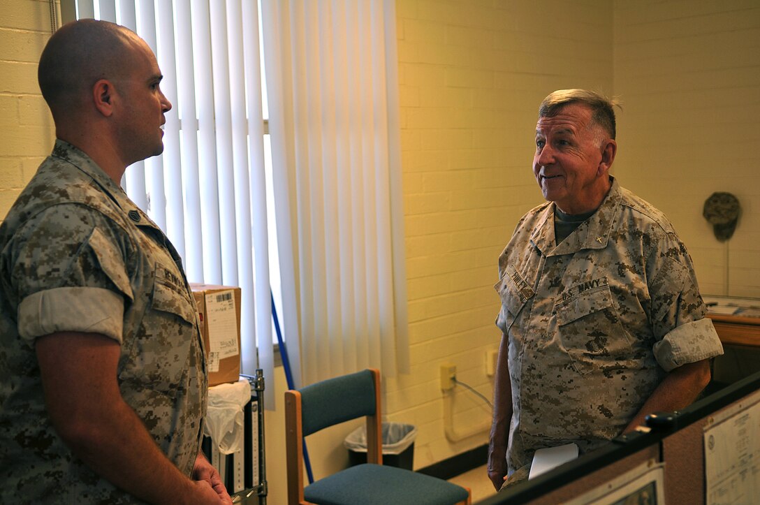 Lt. James Finley, Catholic chaplain for the Marine Corps Air Station in Yuma, Ariz., smiles as he chats with Staff Sgt. Daryl Reynolds, Marine Unmanned Aerial Vehicle Squadron 4 maintenance control chief, during his daily visits to different units on station Sept. 1, 2010. The 73-year-old New York City-native is the oldest sailor in the service, with 47 years in the priesthood, 20 of it as a Navy chaplain.