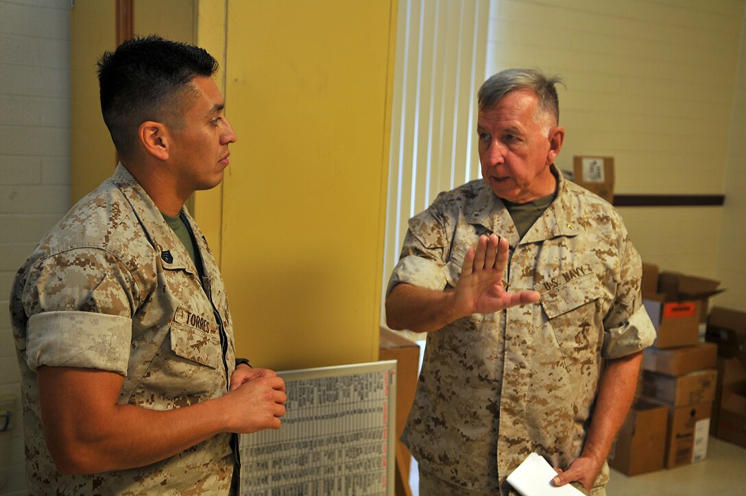 Lt. James Finley, Catholic chaplain for the Marine Corps Air Station in Yuma, Ariz., gestures toward a calendar while asking Staff Sgt. Abel Torres, Marine Unmanned Aerial Vehicle Squadron 4 aviation supply chief, about an upcoming event during his daily visits to different units on station Sept. 1, 2010. The 73-year-old New York City-native is the oldest sailor in the service, with 47 years in the priesthood, 20 of it as a Navy chaplain.