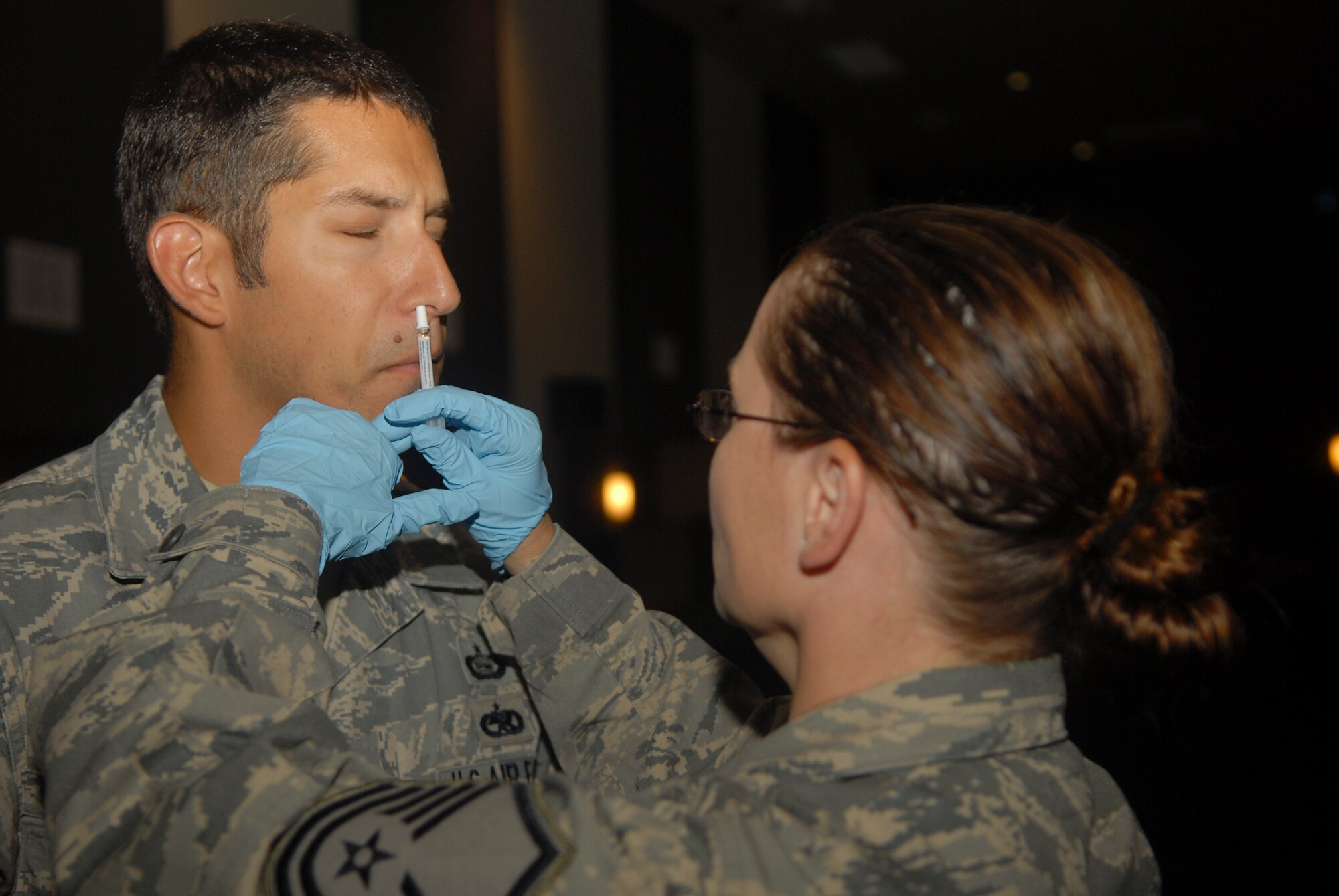 KUNSAN AIR BASE, Republic of Korea -- Master Sgt. Kelly Butterfuss, 8th Medical Group clinical medicine flight chief, administers the FluMist vaccine to an Airman here Sept. 3. The vaccine is mandatory for all active duty, Department of Defense contractors and appropriated funds employees. The flu season starts in October and stretches until May. (U.S. Air Force photo/Senior Airman Ciara Wymbs)  