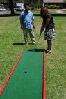 Peter Cruz, from the Pacific Air Forces protocol office and Kehau Amorin, his guest, play miniature golf during the Mahalo Bash Sept. 2, 2010, at Joint Base Pearl Harbor-Hickam. The Mahalo Bash is an annual event hosted by the PACAF commander to thank Airmen and their families for their service and hard work throughout the year. (U.S. Air Force photo/Capt. Alysia Harvey)