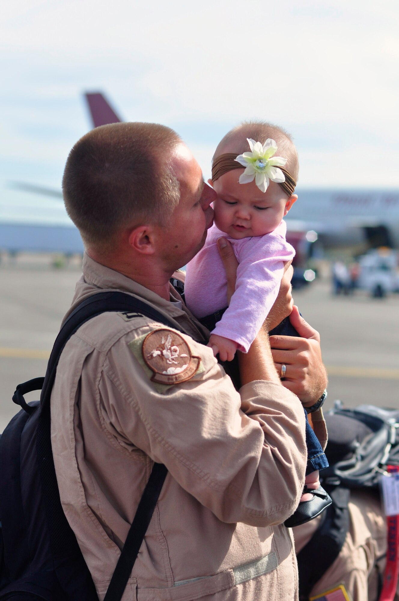 An Airman assigned to the 8th Airlift Squadron gives his daughter a kiss after returning home from a four-month deployment Sept. 2 at Joint Base Lewis-McChord, Wash. (U.S. Air Force photo/Staff Sgt. Robert Tingle)