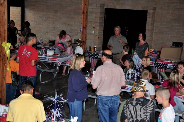 Jim Headstream, Airman & Family Readiness Center, and Tech. Sgt. Pamela Coleman, 90th Forces Support Squadron, hold a raffle during the Deployed Airmen Barbecue held at the base lakes pavilion Friday. The barbecue was for Airmen and their families, who just recently returned from a deployment and those who were tasked to go on a deployment soon. (U.S. Air Force photo by Staff Sgt. Chad Thompson)