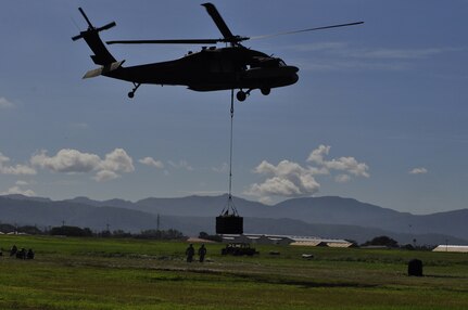 SOTO CANO AIR BASE, Honduras --  Members of Army Forces here stay at a safe distance as a UH-60 Blackhawk helicopter lifts cargo during the bi-monthly sling load training here Sept. 1. ARFOR members learn to rig loads to both a UH-60 and CH-47 Chinook helicopter. (U.S. Air Force photo/Martin Chahin)