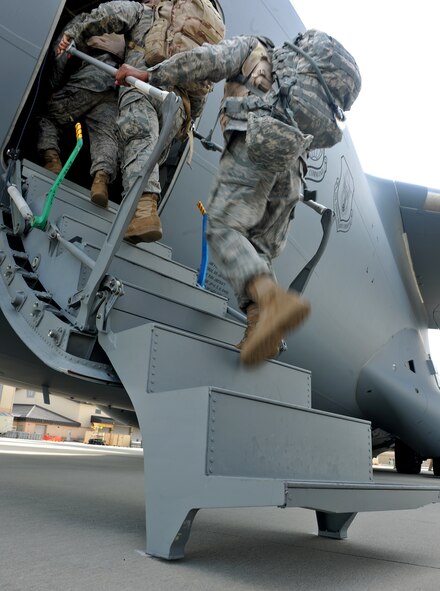 MOODY AIR FORCE BASE, Ga. -- Airmen from the 71st Rescue Squadron, 38th Rescue Squadron and 41st Rescue Squadron “team rescue”, hop on a C-17 Globemaster III ready to deploy here Aug. 26. When all members have deployed we will have provided approximately 1,000 members in support of Operation Enduring Freedom. (U.S. Air Force photo/Airman 1st Class Joshua Green)
