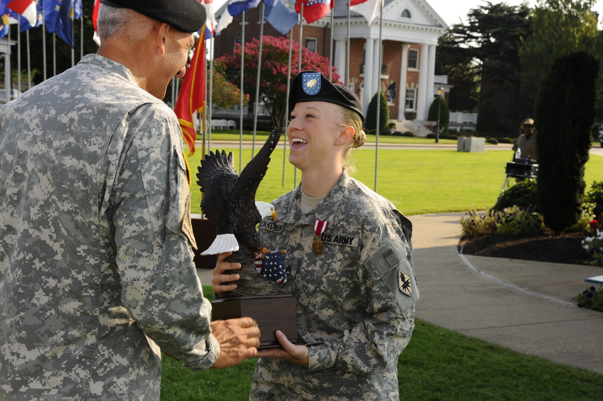 Staff Sgt. Amanda Kokkonen, an advanced individual training platoon sergeant with Alpha Company, 344th Military Intelligence Battalion, Goodfellow Air Force Base, San Angelo, Texas, was named the 2010 Advanced Individual Training Platoon Sergeant of the Year this morning during a military ceremony on Continental Park on Fort Monroe, Va. Kokkonen receives the AIT Platoon Sergeant of the Year trophy from Lt. Gen. Mark P. Hertling, deputy commanding general for Initial Military Training. (U.S. Army photo/ Frank Brown)