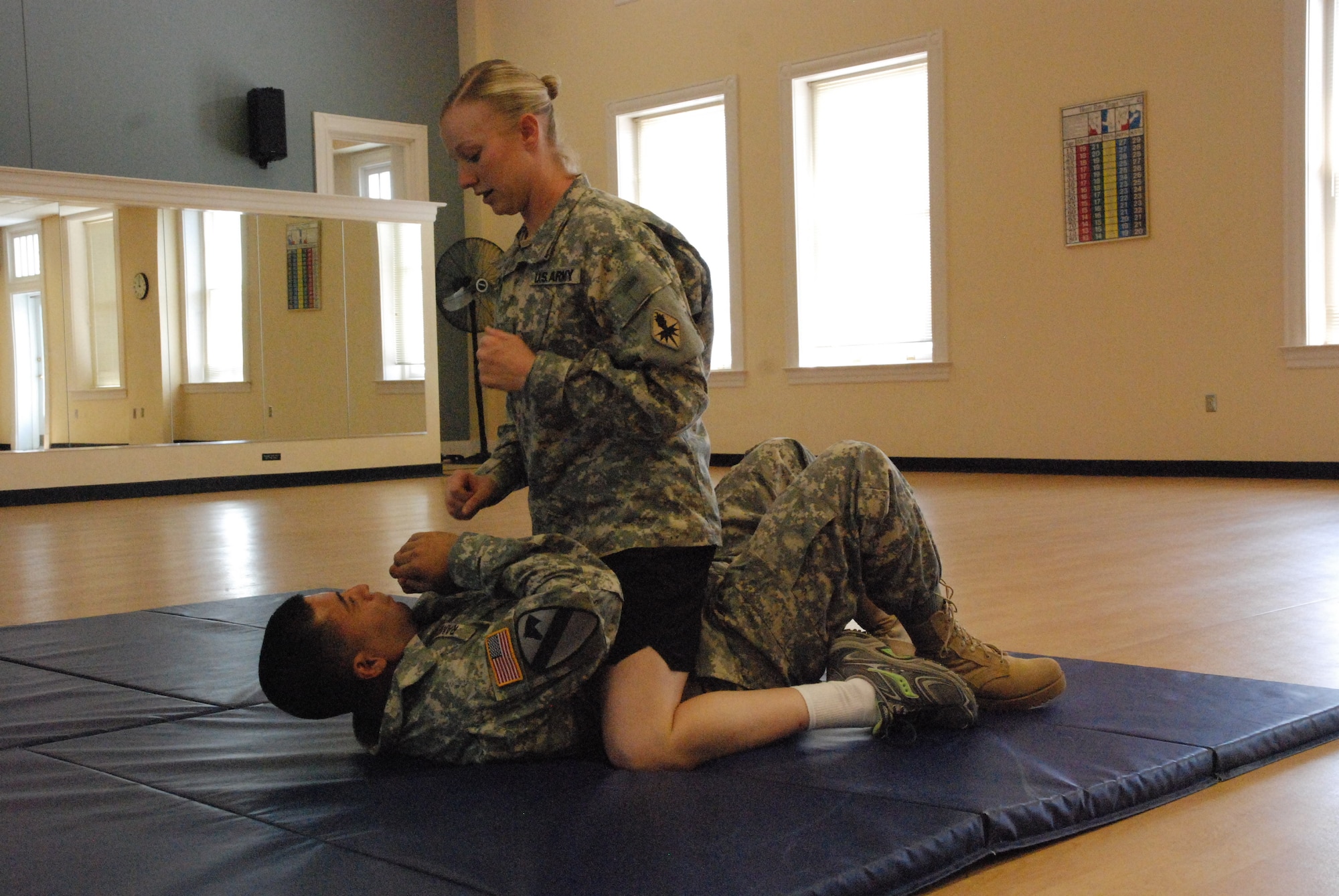 Army Staff Sgt. Amanda Kokkonen, an AIT Platoon Sergeant at Fort Huachuca, Ariz., teaches her combatives partner what to expect if his opponent strikes from the mounted position during the 2010 AIT Platoon Sergeant of the Year Competition at Fort Monroe, Va. (U.S. Army photo/ Carroll Kim)