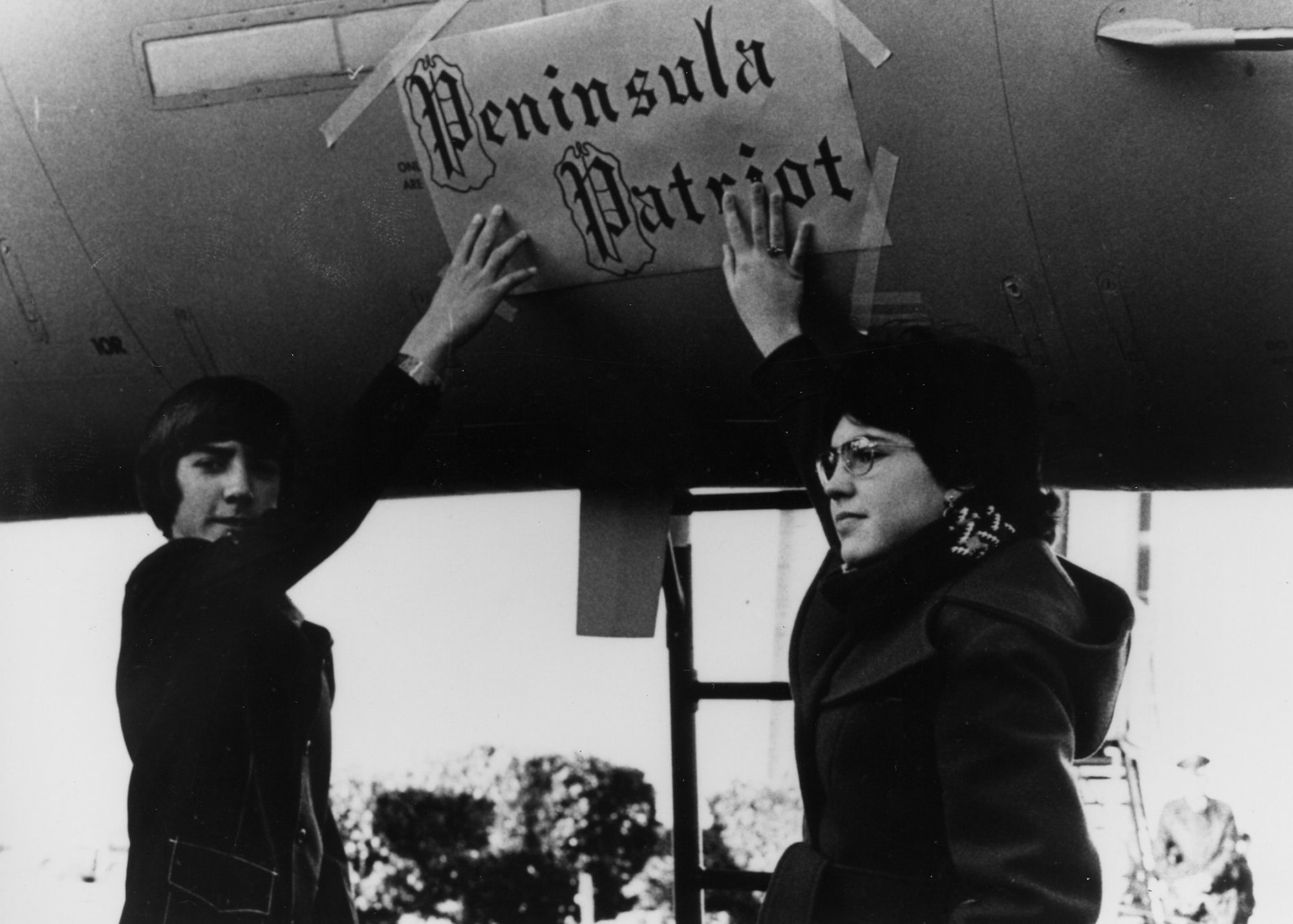 LANGLEY AIR FORCE BASE, Va.--  Kyle Shockely (left) and Terri Ewell (Morris), winners of the grade school Name the F-15 Contest, place their choice, “Peninsula Patriot,” on the side of the first Eagle based here Jan. 9, 1976. (U.S. Air Force photo/Sgt. Thom Jennings)