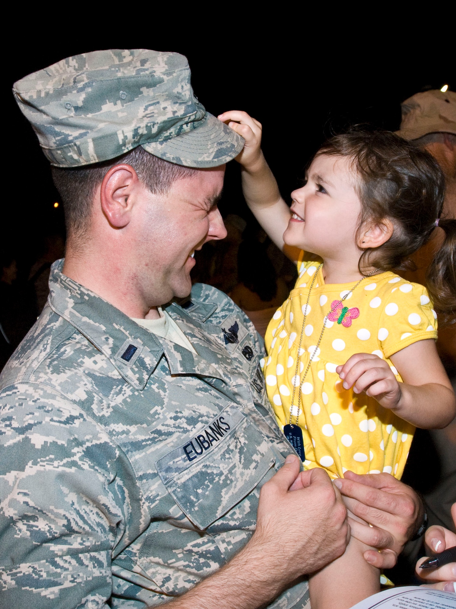 1st Lt. Cory Eubanks, 19th Aircraft Maintenance Squadron, gets help adjusting his hat from his daughter Ryleigh, 3, Sept. 1 at the Little Rock Air Force Base passenger terminal. More than 160 Airmen returned home from deployments in Southwest Asia. (U.S. Air Force photo by Staff Sgt. Nestor Cruz)