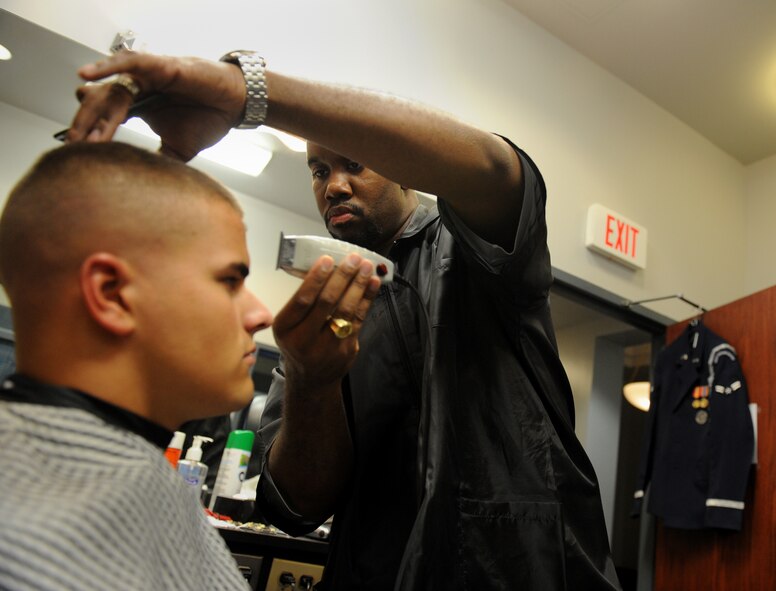 BOLLING AFB, D.C. -- A member of the Air Force Honor Guard receives a hair cut before preparing for his day of ceremonies at Arlington National Cemetery here Aug. 23. The Airmen have a barber shop located in their dormitory, which is also located next to their practice areas and armory. (U.S. Air Force photo/Staff Sgt. Gina Chiaverotti-Paige)