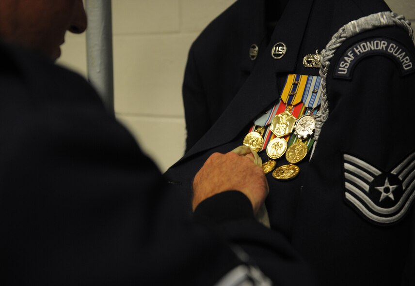 BOLLING AFB, D.C. -- A member of the Air Force Honor Guard cleans the medals on his uniform before beginning his day here Aug. 23. An average duty day starts at 5:30 a.m. and ends around 5 p.m. (U.S. Air Force photo/Staff Sgt. Gina Chiaverotti-Paige)
