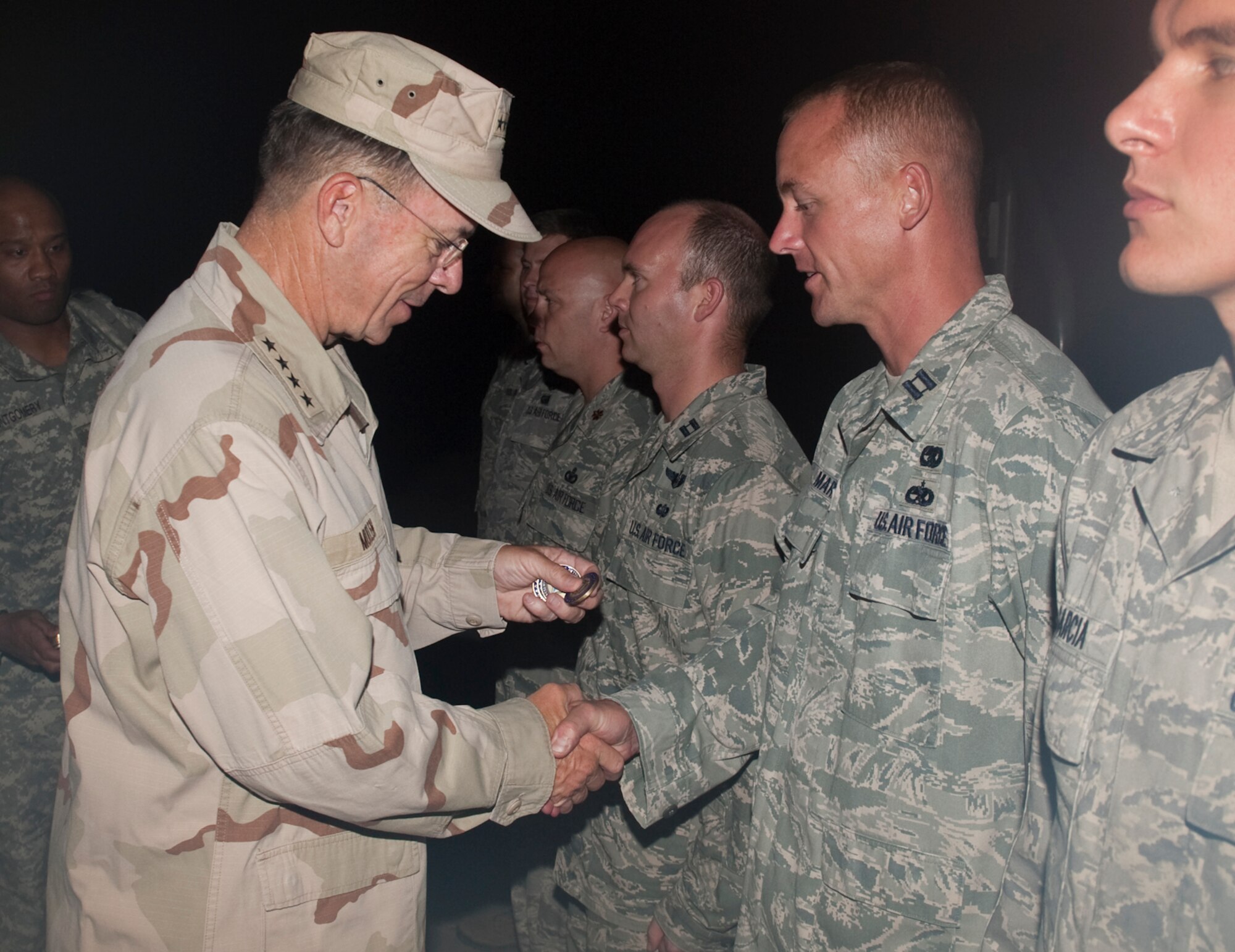 Navy Adm. Mike Mullen, chairman of the Joint Chiefs of Staff coins Airmen from the 621st Contingency Response Wing during a visit to Islamabad, Pakistan on Sept. 1, 2010. The 40 Airmen from the 621 CRW are at Chaklala Air Force Base, Pakistan, providing additional manpower, equipment and organization to current flood relief operations out of Pakistan’s Flood Relief Cell. (DoD Photo by Mass Communication Specialist 1st Class Chad J. McNeeley/Released)