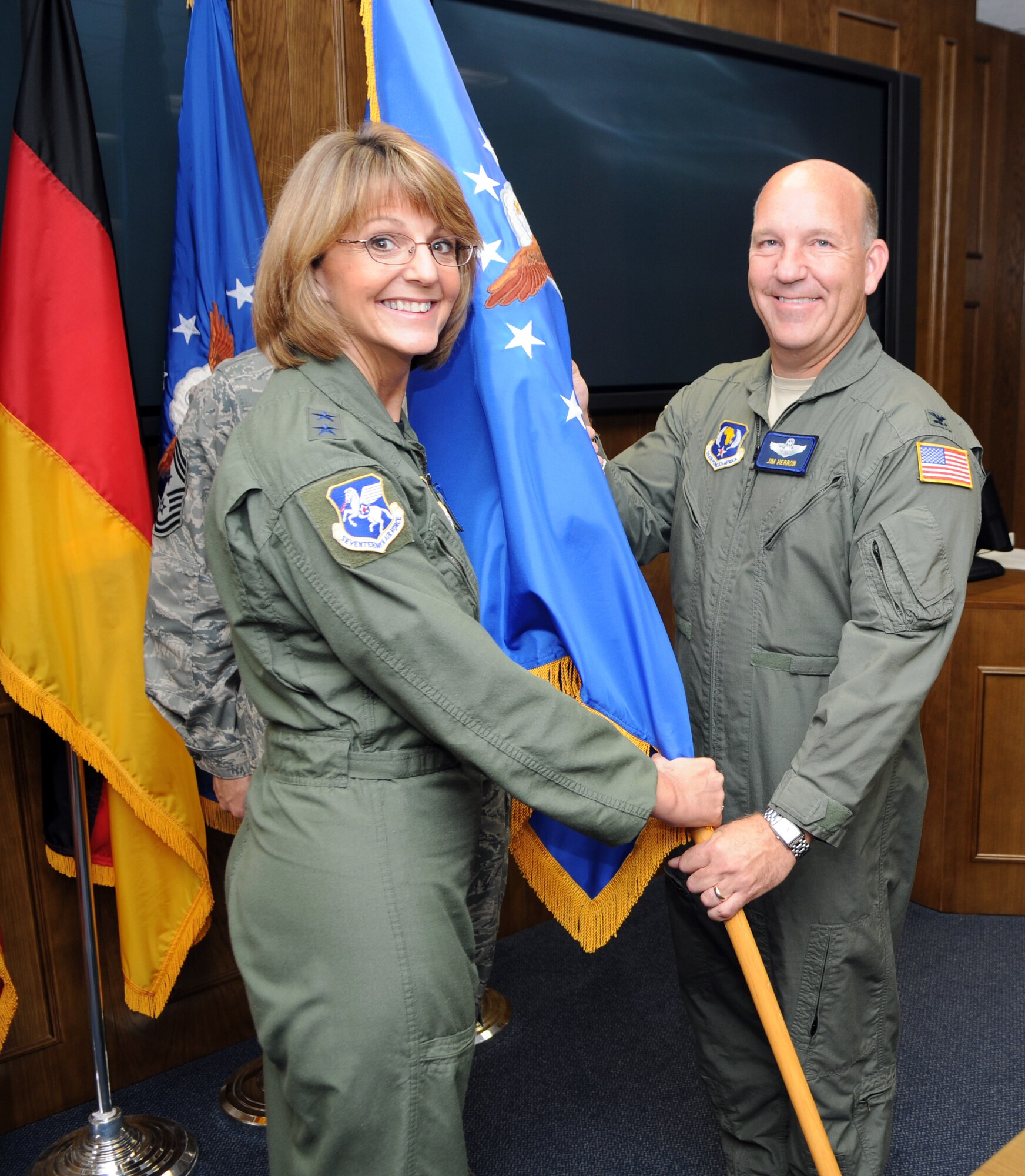 RAMSTEIN AIR BASE, Germany -- Major, Gen. Margaret H. Woodward (left), commander of 17th Air Force (Air Forces Africa) passes the guidon to the new 404th Air Expeditionary Group commander Col. James Herron during a assumption of command ceremony at Aug. 10. (U.S. Air Force photo by Staff Sergeant Jodi Leininger)