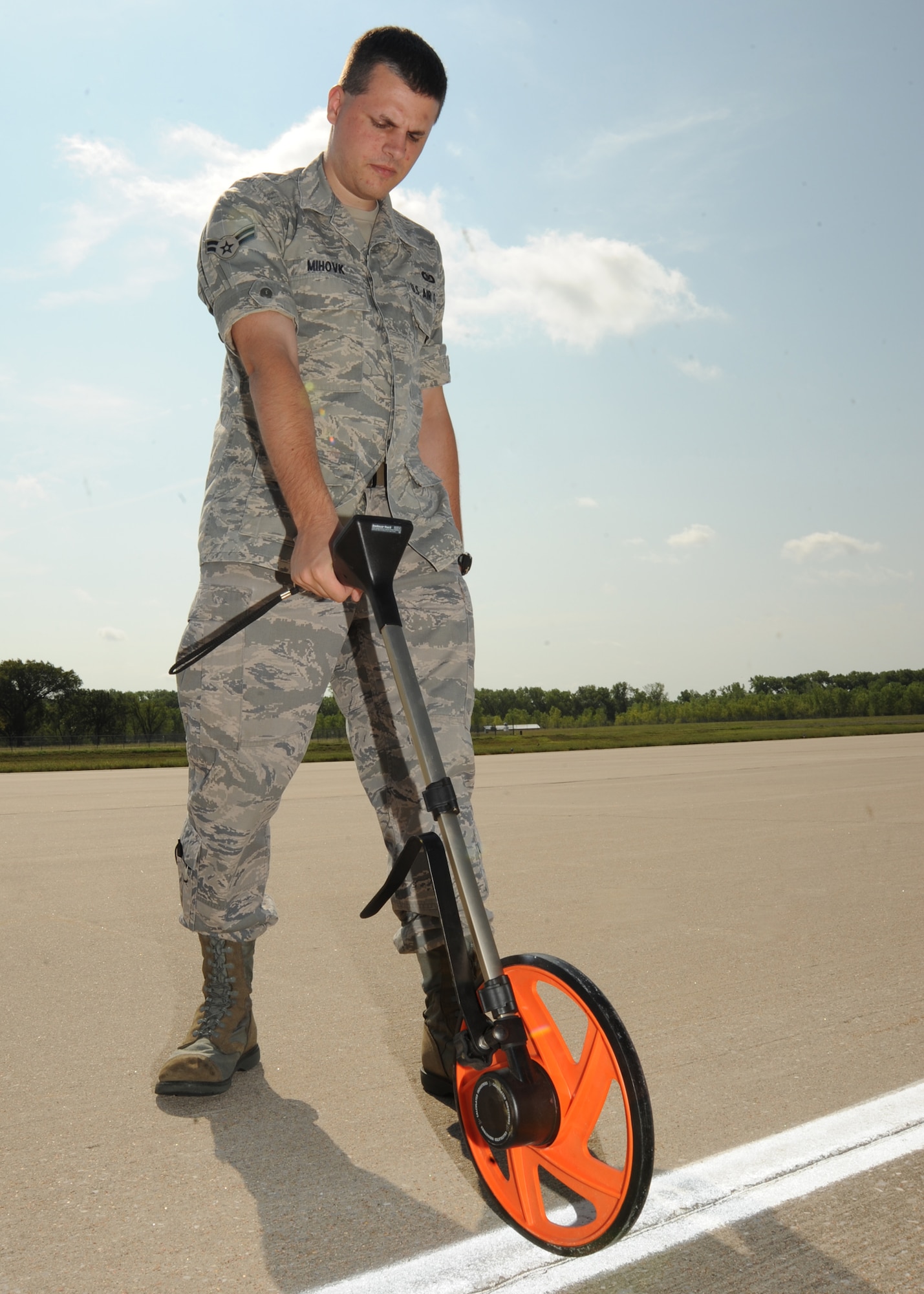 Airman 1st Class Jonathan Mihovk, 22nd Operations Support Squadron airfield management shift leader, measures the “wing-tip” clearance on the airfield Aug. 31, 2010, McConnell Air Force Base, Kan.  Measuring the clearance ensures aircraft have enough space to safely taxi and park on the airfield.  (U.S. Air Force photo/Airman 1st Class Andrea Salazar)