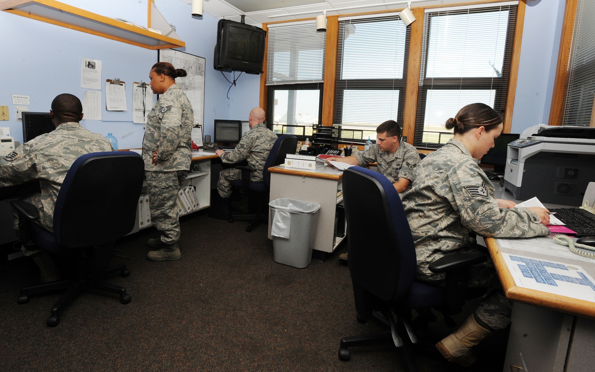 Airmen from the 22nd Operations Support Squadron airfield management flight, work at the operations desk Aug. 31, 2010, McConnell Air Force Base, Kan.  Daily operations include coordinating flight plans, maintaining publications for pilots, monitoring aircraft that land at McConnell and performing lighting and runway checks.  Airfield management personnel oversee McConnell’s 654 acre airfield and ensure all the pavement, markings and lighting are within limits set by Air Force regulations.  (U.S. Air Force photo/Airman 1st Class Andrea Salazar)