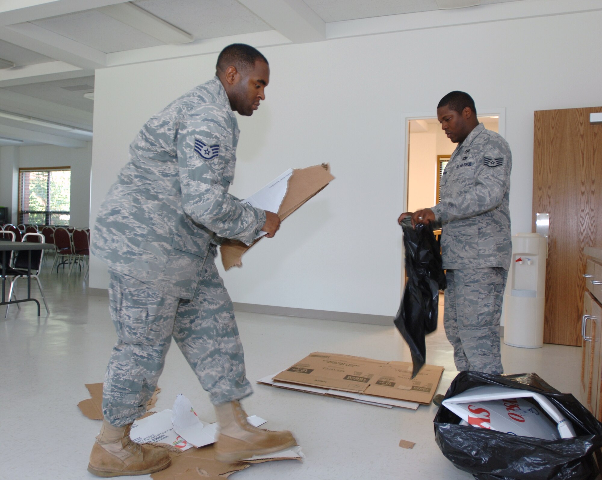 LANGLEY AIR FORCE BASE, Va. -- Staff Sgts. Stephen A. King (left) and Aaron Goodrum, 633d Air Base Wing chaplain’s assistants, break down boxes during the final stages of clean-up at the Bethel Manor chapel Sept. 1. The chapel will reopen Sept. 5 following seven months of renovations. (U.S. Air Force photo/Airman 1st Class Jason J. Brown) (released)