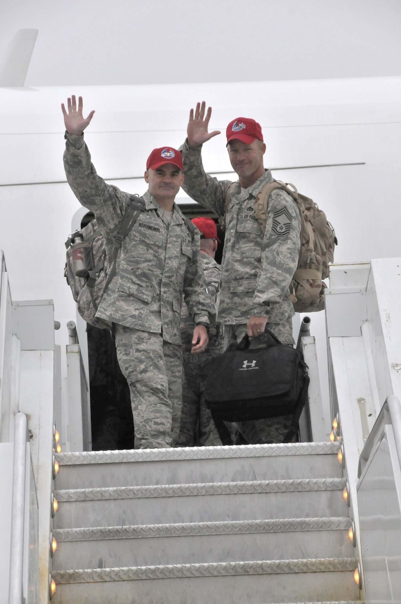 Col. Gregory Rosenmerkel, 819th RED HORSE SQUADRON commander, and Chief Master Sgt. Timothy Zumbrun, 219th RHS chief of logistics, give a final wave as they prepare to board an aircraft departing for a deployment to Southwest Asia Aug. 30.(U.S. Air Force photo/John Turner)